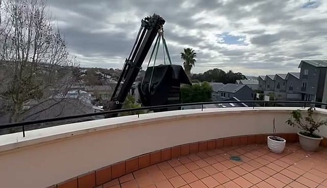 Crane lifting a piano to an upper balcony, Specialist Movers