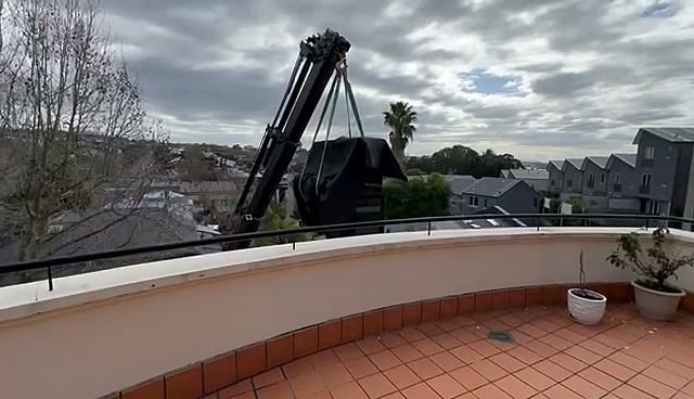 Crane lifting a piano to an upper balcony, Specialist Movers